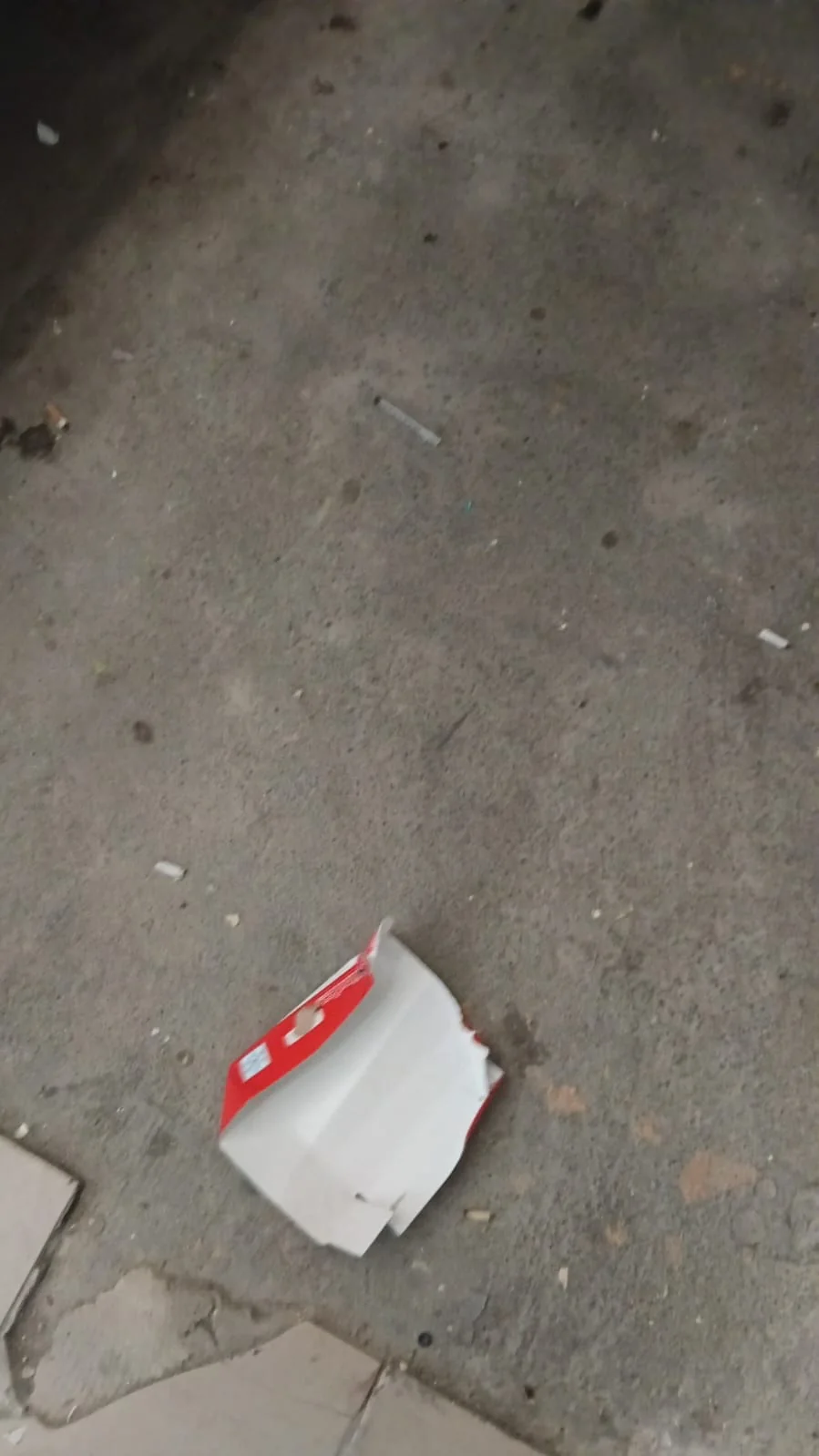 Odpad a injekční stříkačka na podlaze ve společných prostorách domu