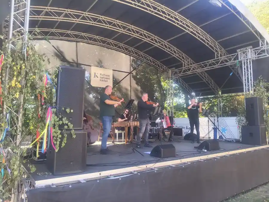 Muzikanti s houslemi, cimbálem a dalšími nástroji na kadaňském vinobraní